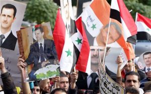 Supporters of Syrian President Bashar al-Assad outside the Foreign Ministary in Damascus (Louai Beshara/AFP/Getty Images)
